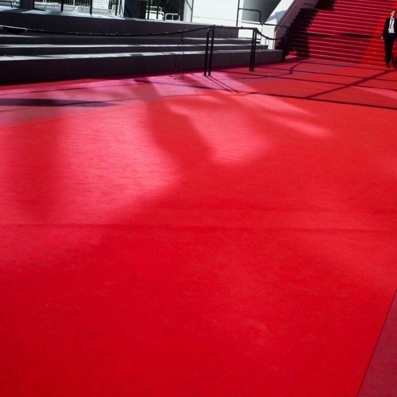 Iconic vibrant red event carpet leading to an outdoor grand staircase.