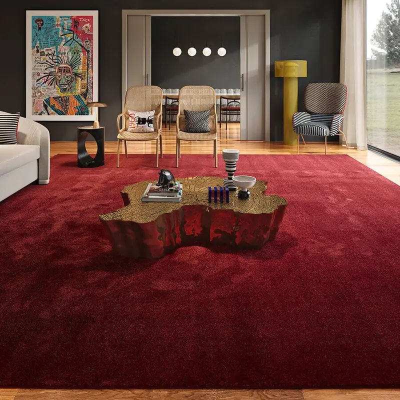 Luxurious deep red plush area rug in a modern living room setting.