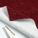 Red carpet swatch showing white felt backing.