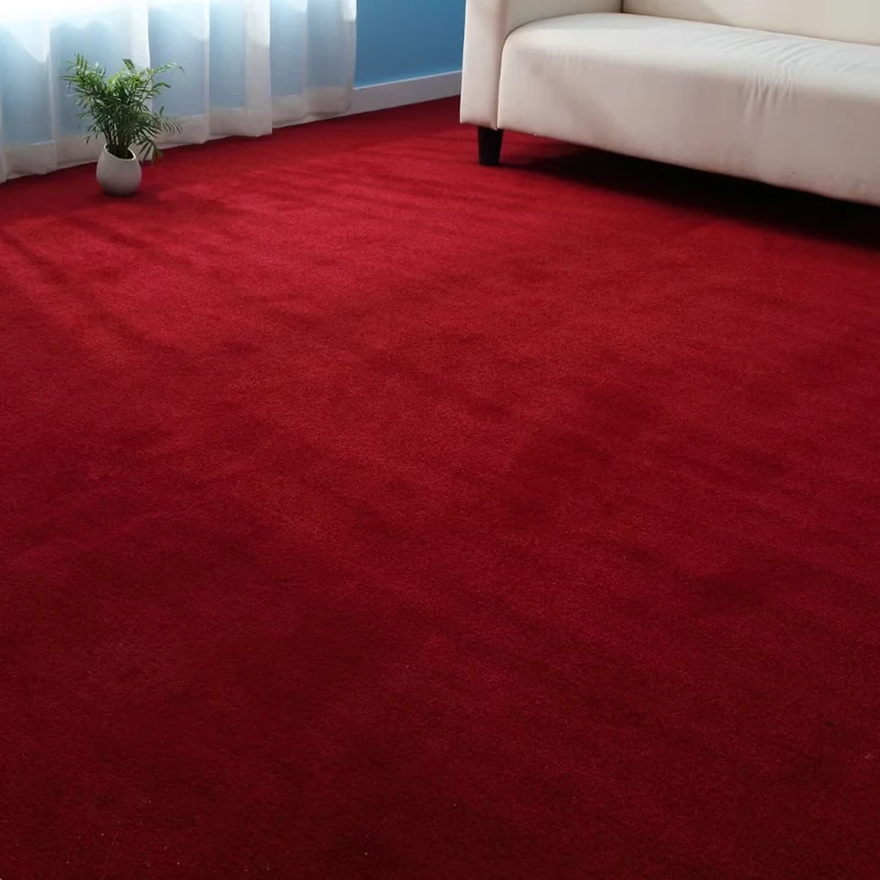 Vibrant red plush carpet in a bright living room with a white sofa.